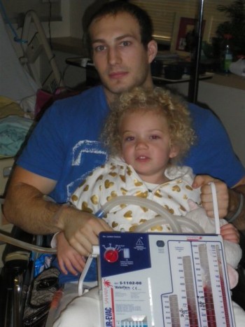 Picture of young man in hospital with daughter after loss of his lung.