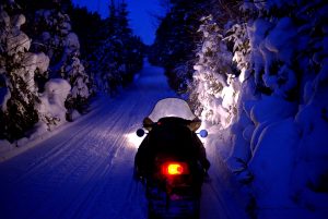 Snowmobile on a trail after dark.